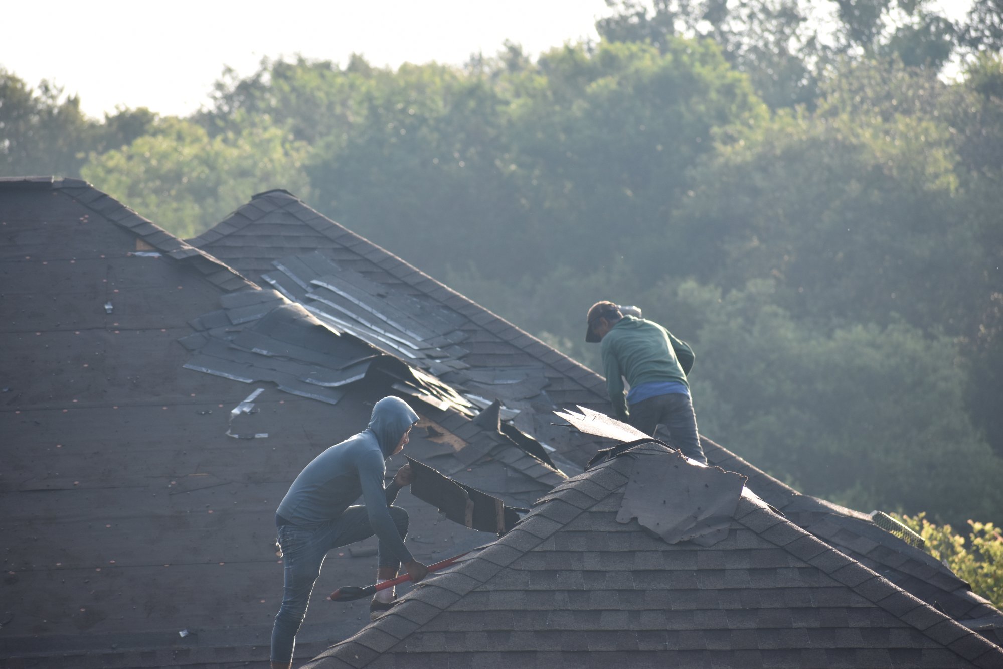 Roofing crew actively working on a residential roof replacement in Kyle TX